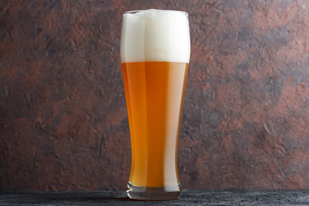 Glass of unfiltered wheat beer on brown concrete backgroundの写真素材