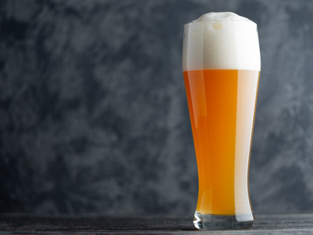 A glass of wheat unfiltered beer on a dark background with copyspaceの写真素材