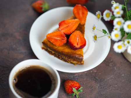 A Cup of espresso and strawberry pie on the tableの写真素材