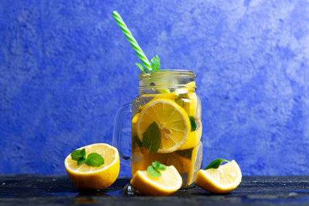 Lemonade in a glass jar with lemon, mint and ice. Mojito in glass