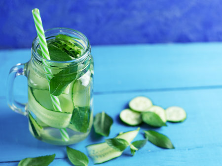 Cucumber infused water with mint on wooden blue background with copyspaceの写真素材