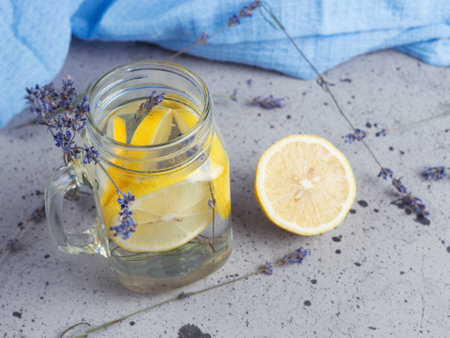 Lavender water with lemon in a jar on a blue backgroundの写真素材