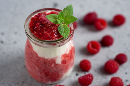 Raspberry parfait dessert Breakfast in glass jar on gray tableの写真素材