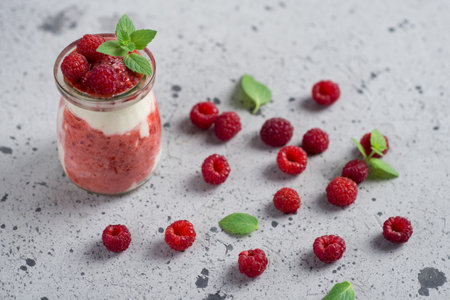 Raspberry parfait dessert Breakfast in glass jar on gray tableの写真素材
