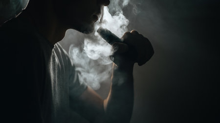 Close - up of vaper man exhales a cloud of steam . electronic cigarette mod