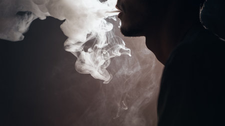 Close - up of vaper man exhales a cloud of steam . electronic cigarette modの写真素材