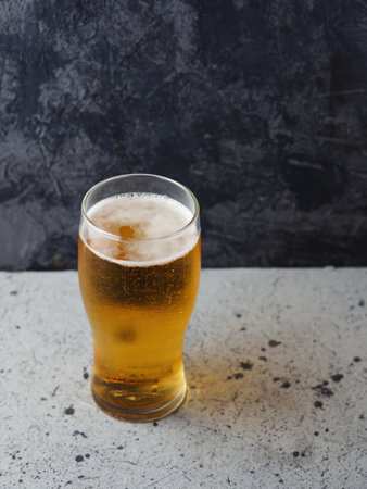 A glass of light beer on a dark backgroundの写真素材