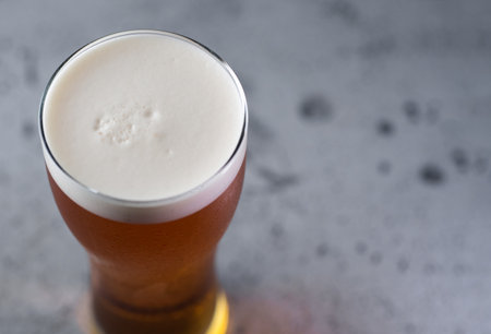 Close up of a glass of nitrogen beer on a gray tableの写真素材
