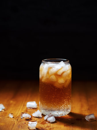 Cold espresso coffee tonic in a glass with ice on a wooden tableの写真素材