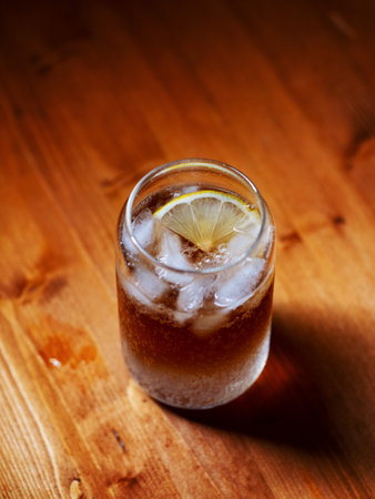 Cold espresso coffee tonic in a glass with ice on a wooden tableの写真素材
