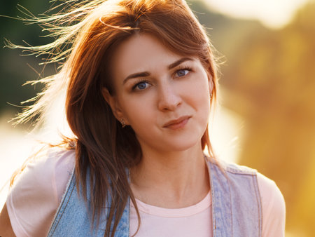 Close-up portrait of a beautiful woman at sunsetの写真素材
