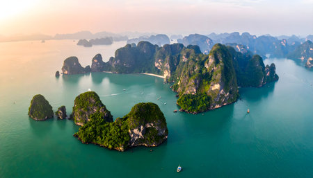 Stunning sunset over a tropical island archipelago, with lush green peaks casting long shadows across the clear, calm ocean waterの素材