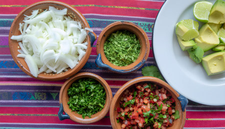 Vibrant, energetic overhead flat lay of taco truck "mise en place," featuring chopped onions, cilantro, limes, and avocado.の素材