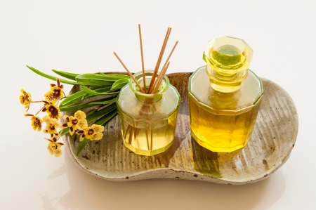 Aromatic essence oil bottle with bottle of fragrance reeds diffuser and bunch orchid flower 