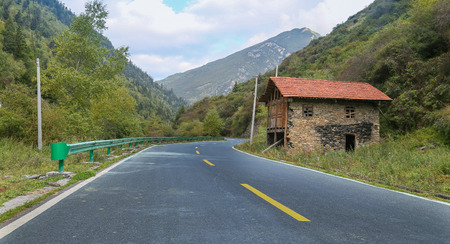 road in the mountain with discarded houseのeditorial素材