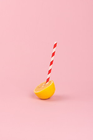 Orange with a straw on pink backgroundの写真素材