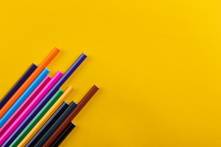 Colored pencils on yellow background
