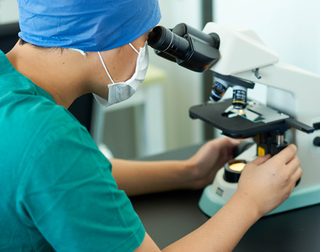 doctor doing research with a microscope.のeditorial素材