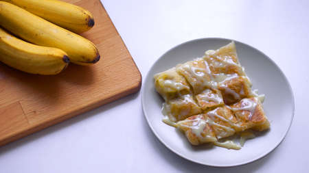 thai banana roti style with banana on wooden boardの写真素材