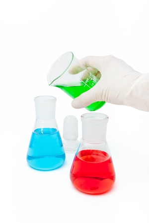 Colored solution in laboratory flasks with latex-gloved handの写真素材