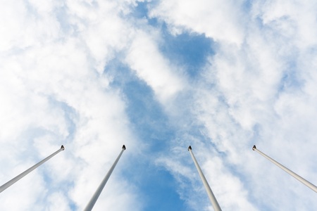 Underview of four masts without flags and cloudy backgroundの写真素材