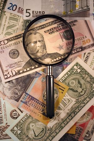 Magnifying glass with US, AUS and Euro currency
