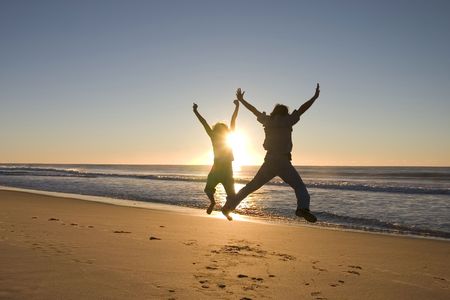 Happy people jumping around at sunriseの写真素材