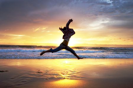 Woman jumps at sunriseの写真素材