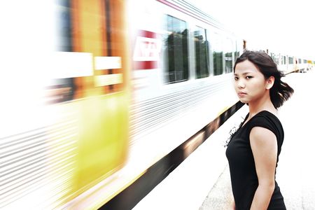 Business Woman waiting for the incoming train at Melbourne station, Australiaの写真素材