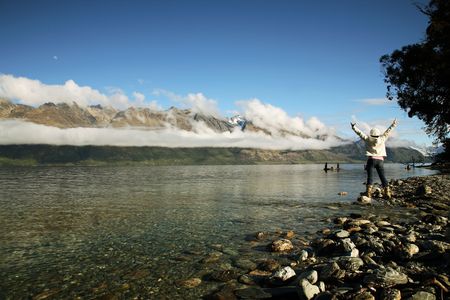 Victorious woman standing at New Zealand Lakeの写真素材