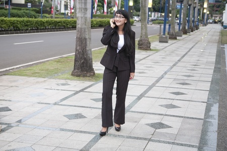 businesswoman making a phone call on the streetの写真素材