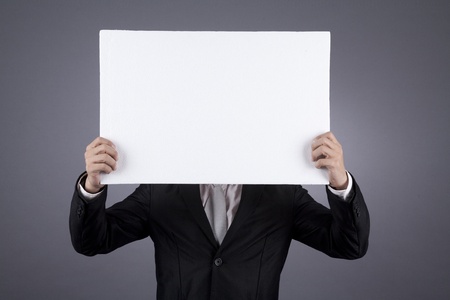 Businessman holding a blank sign shot in studioの写真素材