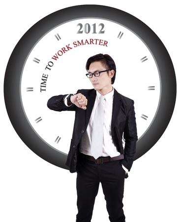 Asian businessman in suit isolated on white with big clock in backgroundの写真素材