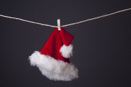 conceptual photo of santa claus hat hanging isolated on greyの写真素材