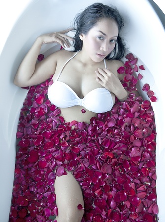 Beautiful asian woman bath flower with rose petalsの写真素材