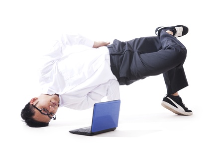 Businessman performing breakdancing with laptopの写真素材