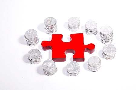 Isolated red puzzle in the center of silver coins circleの写真素材