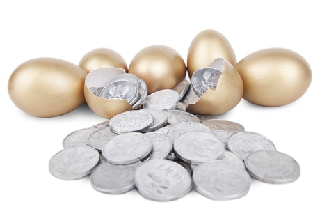 Golden eggs with coins on white background