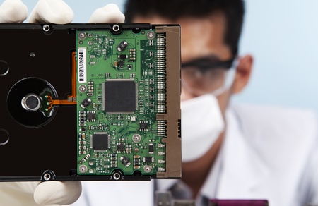A scientist showing a computer harddisk shot in laboratory