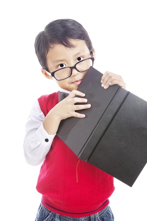 Portrait of male elementary school student holding book. shot in studioの写真素材