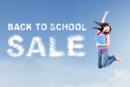 Text of back to school sale with female college student jumps on the side of textの写真素材