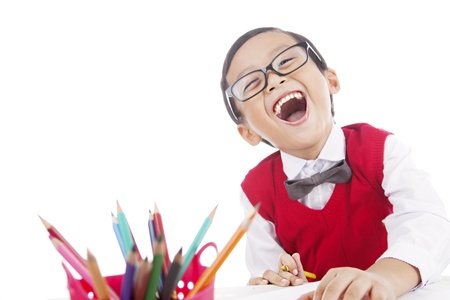 Portrait of cheerful male pupil holding a pencil crayon to draw on the paper. isolated on whiteの写真素材