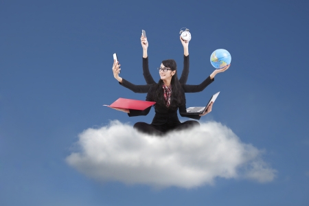 Beautiful asian business woman looking confident with six arms sitting on a cloud