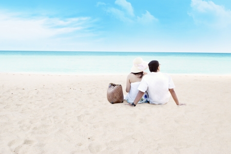 Young couple sitting together on beach. shot at tropical beachの写真素材