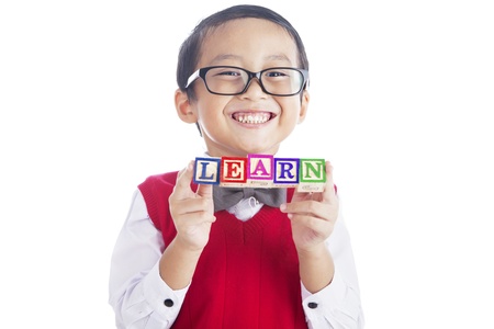 Portrait of asian elementary school student showing LEARN word. shot in studio isolated on whiteの写真素材