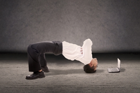 Attractive businessman doing breakdance style with laptop computerの写真素材