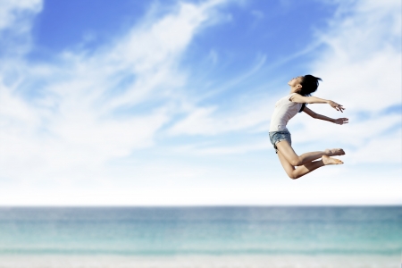 Asian woman flying at the beach. Copy space available for your own textの写真素材