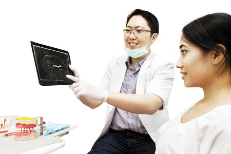 Portrait of asian dentist showing dental x-ray to his patient at dental clinicの写真素材