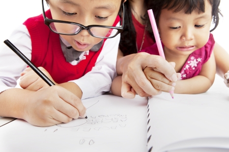 Portrait of young asian children write on the paper. shot at homeの写真素材
