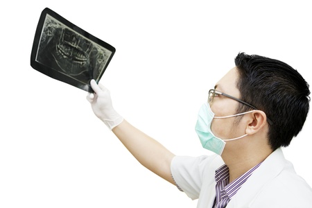 Portrait of asian dentist checking dental x-ray. isolated on whiteの写真素材